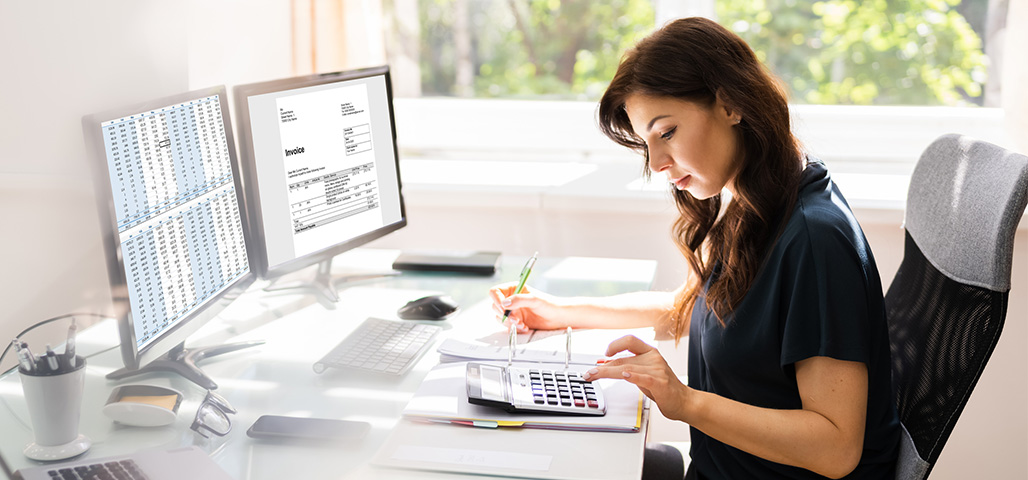 Accountant Using Invoice Software At Computer