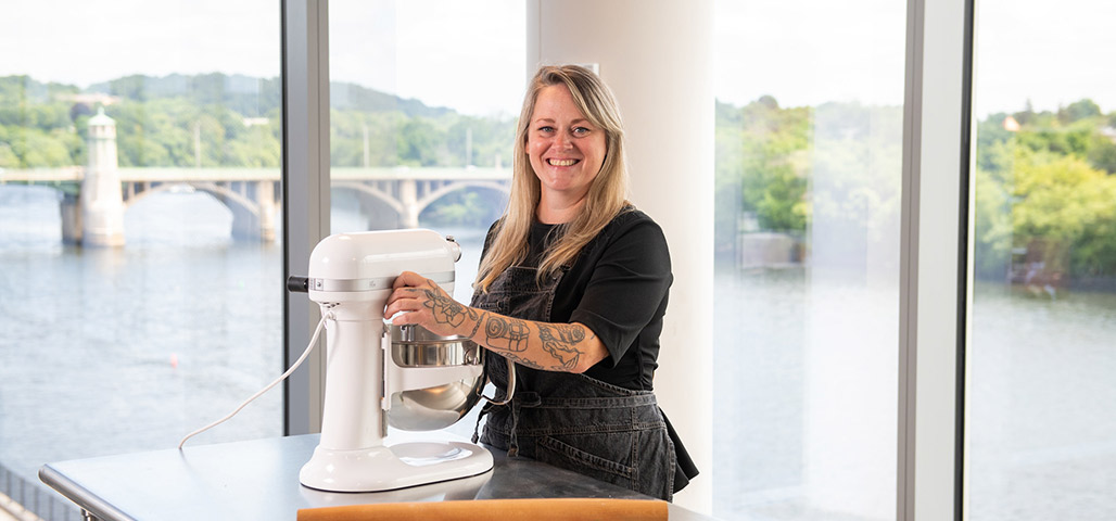 Woman standing in a kitchen in front of a mixer.