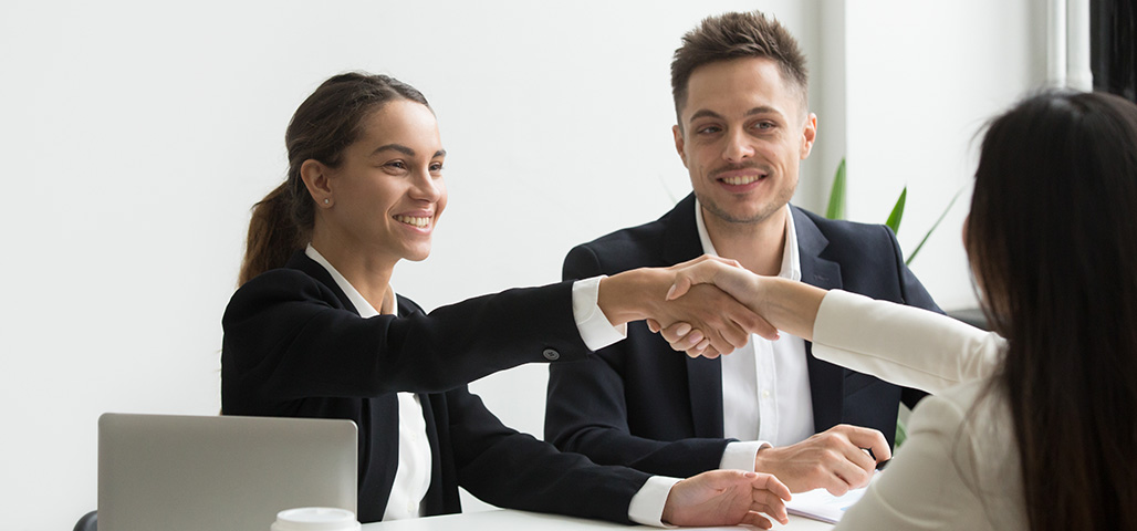 Woman shaking hands with other woman.